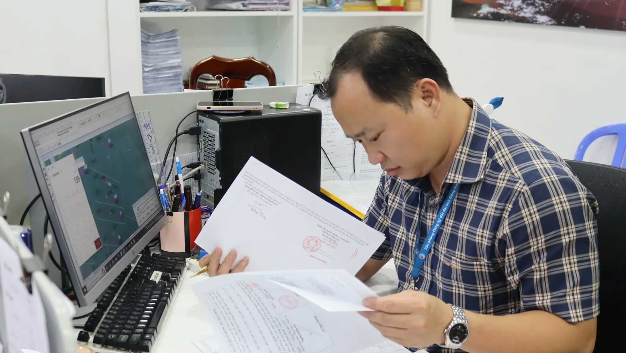 Nhân viên Văn phòng Đăng ký Đất đai tỉnh Đồng Nai đang thẩm tra hồ sơ hoàn công nhà ở trên hệ thống phần mềm GIS, màn hình hiển thị bản đồ địa chính VN-2000 với lớp dữ liệu công trình được chồng lên nền thửa đất